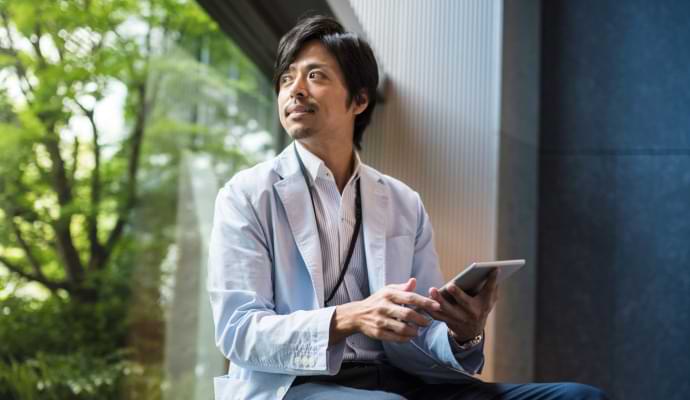 ノートン 360 スタンダードが稼働している携帯電話を見ながら食事をしている男性